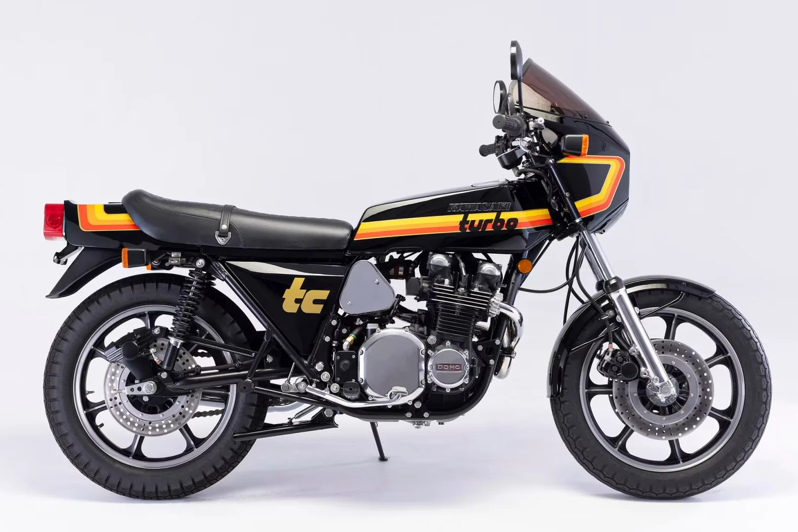 Black Kawasaki turbo motorcycle with yellow and orange stripes and black leather seat on a white background.