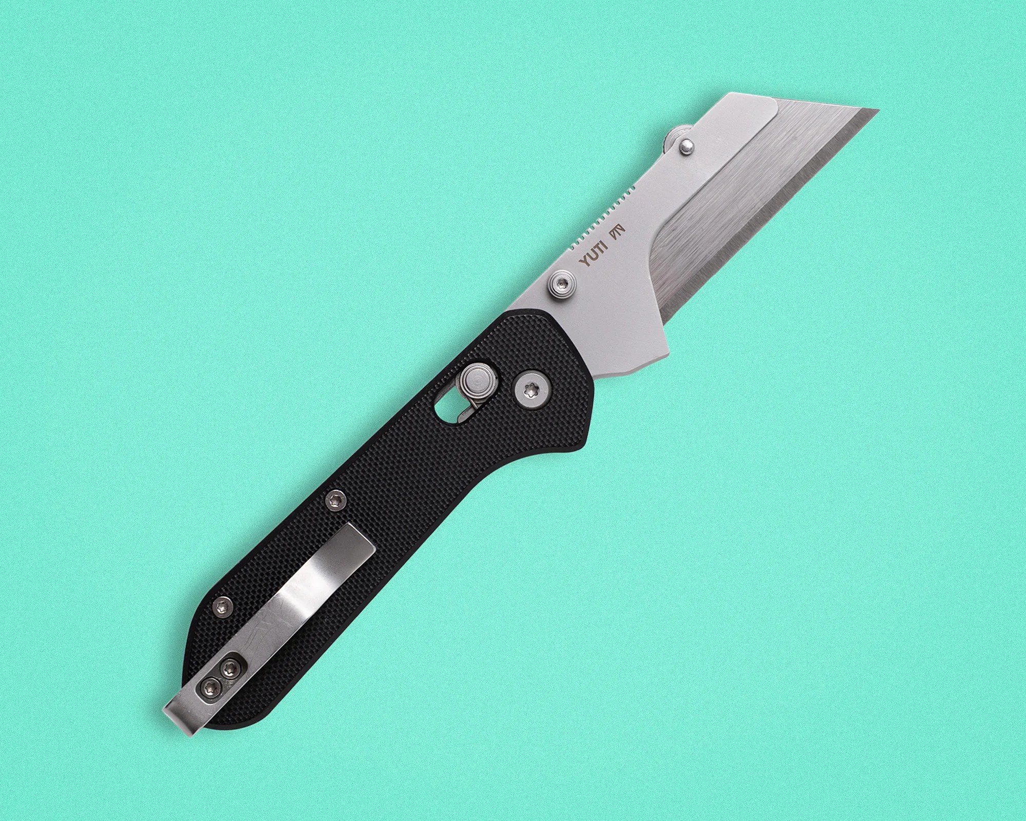 Folding utility knife with a black textured handle and a silver blade on a turquoise background.