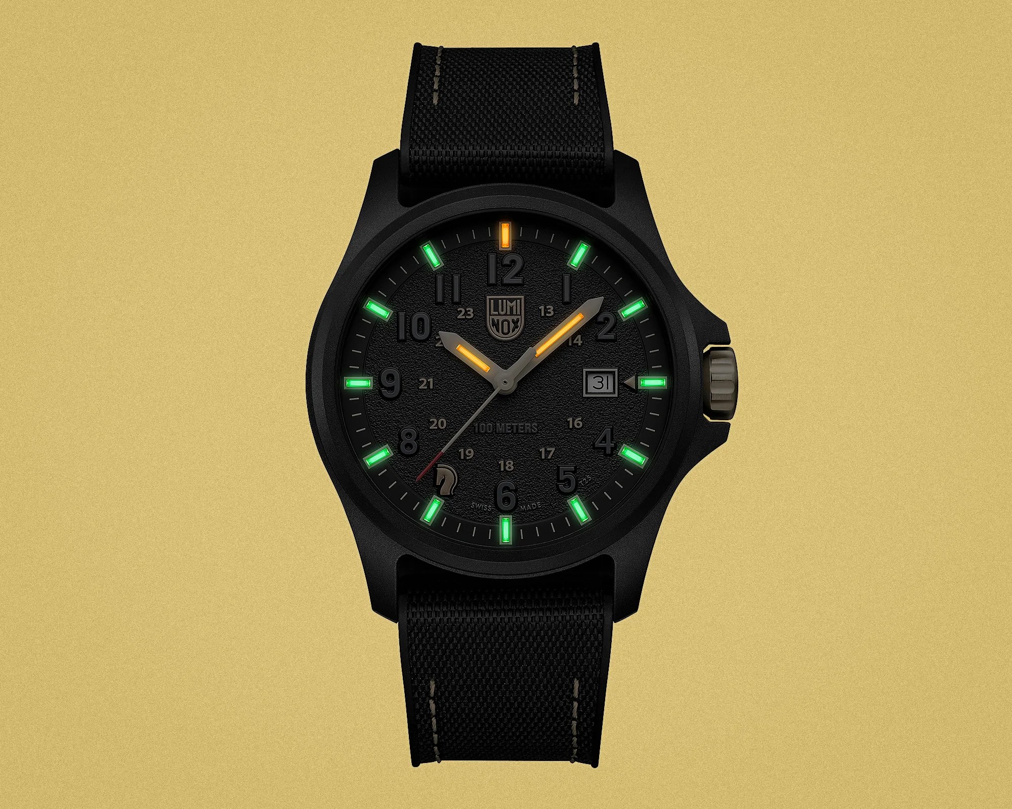 Black Luminox wristwatch with green and orange luminescent hour markers and hands, black fabric strap, and date display.