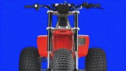 Front view of a red three-wheeled ATV with large knobby tires and black handlebars against a blue background.
