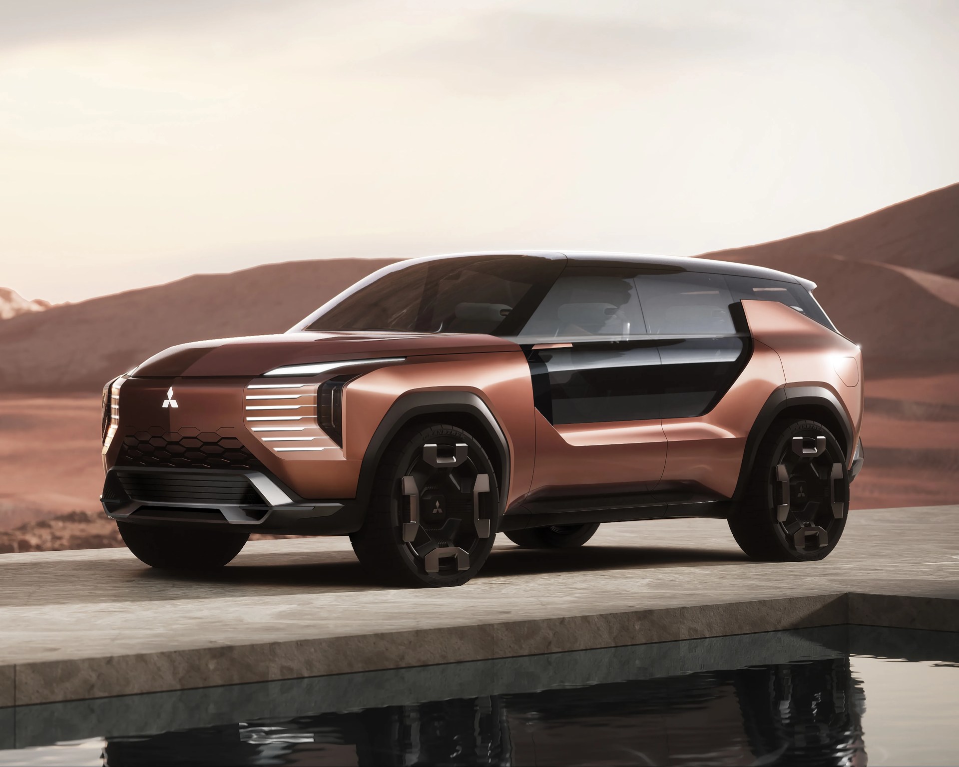 Copper-colored futuristic Mitsubishi SUV concept with black accents parked on a stone platform near water.