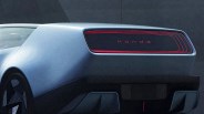 Rear view of a silver Honda car with a futuristic black and red taillight panel and geometric wheel design.