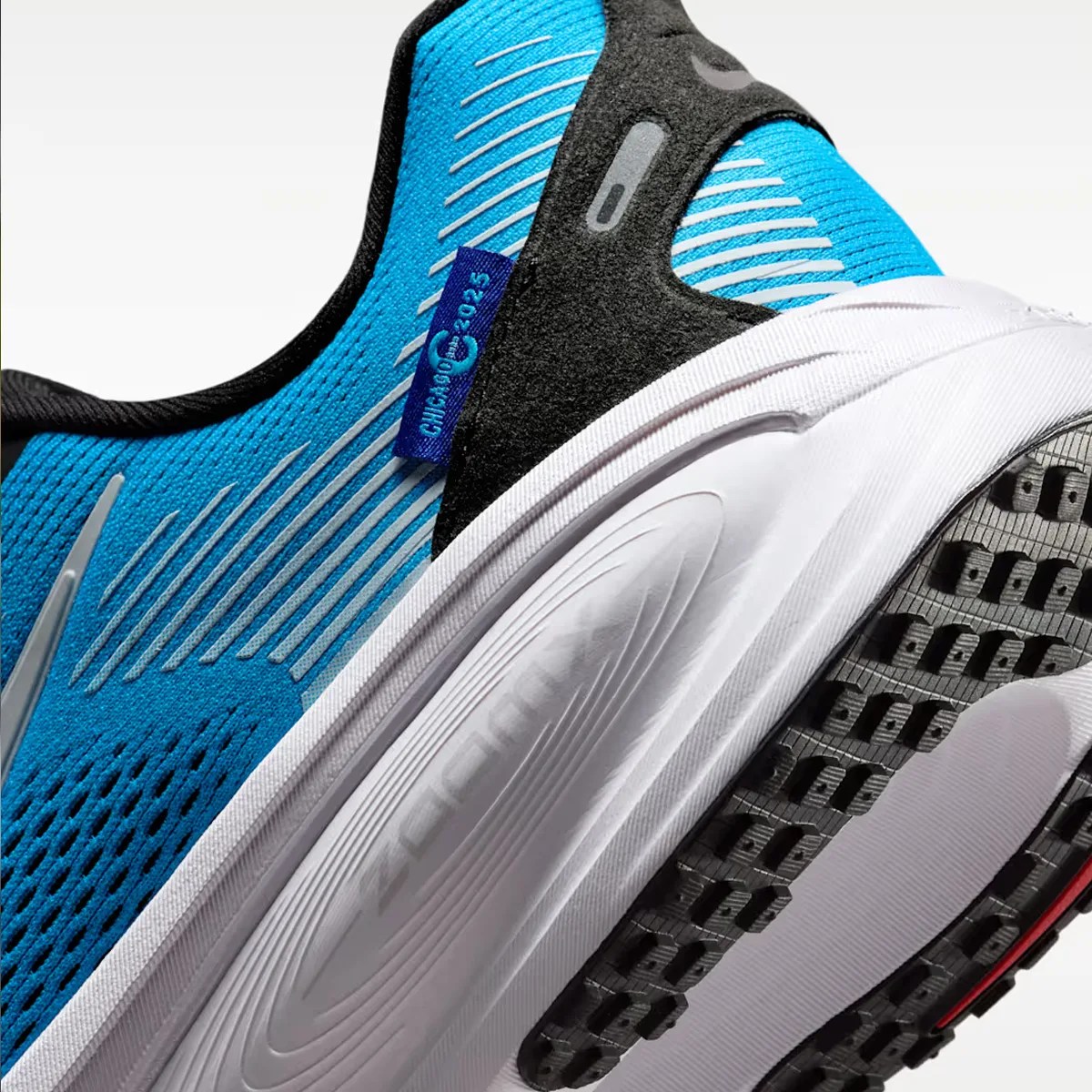 Close-up of a blue and black running shoe with white midsole and black textured outsole.