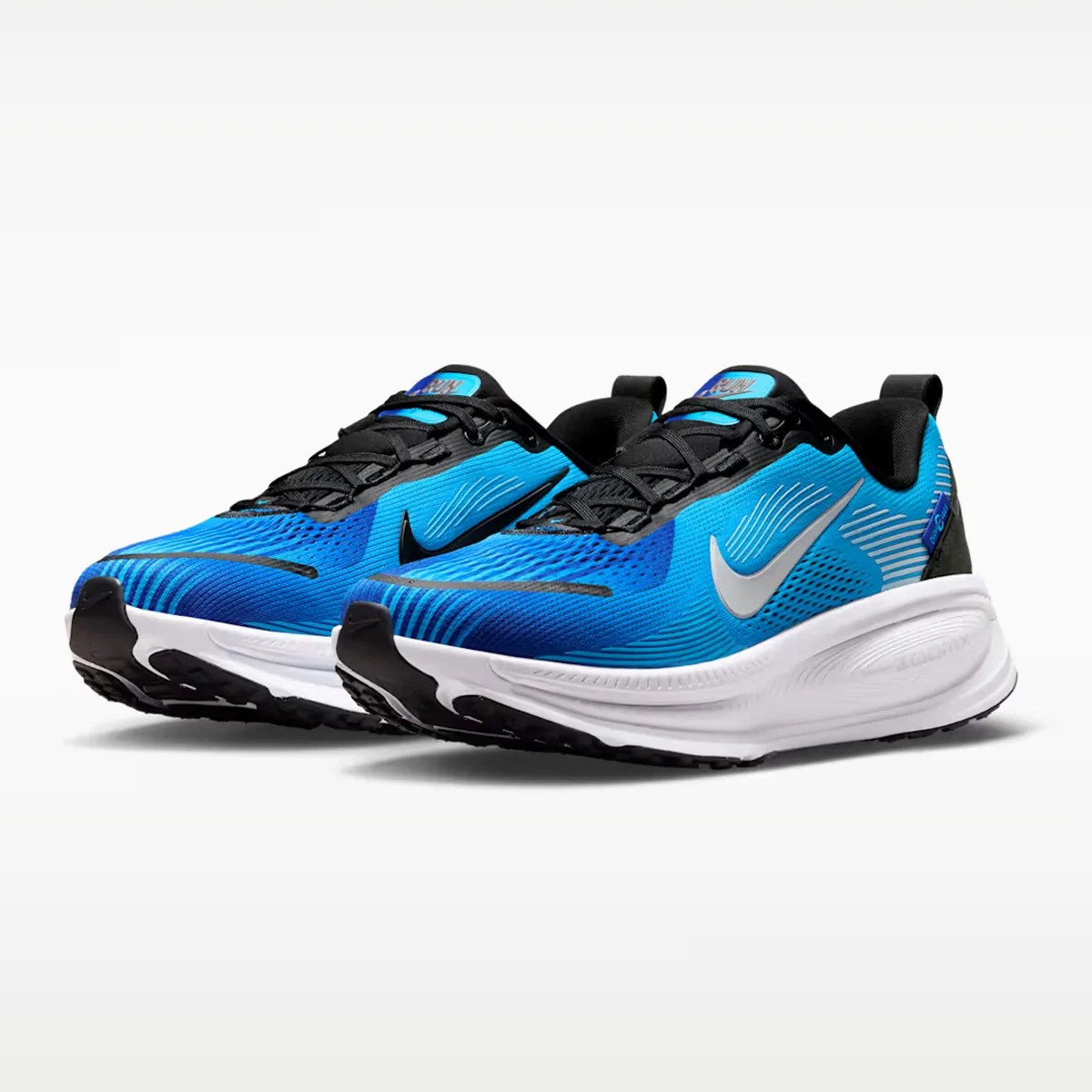 Pair of blue and black Nike running shoes with white soles on a white background.