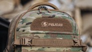 Camouflage Pelican backpack with brown straps and a top handle.