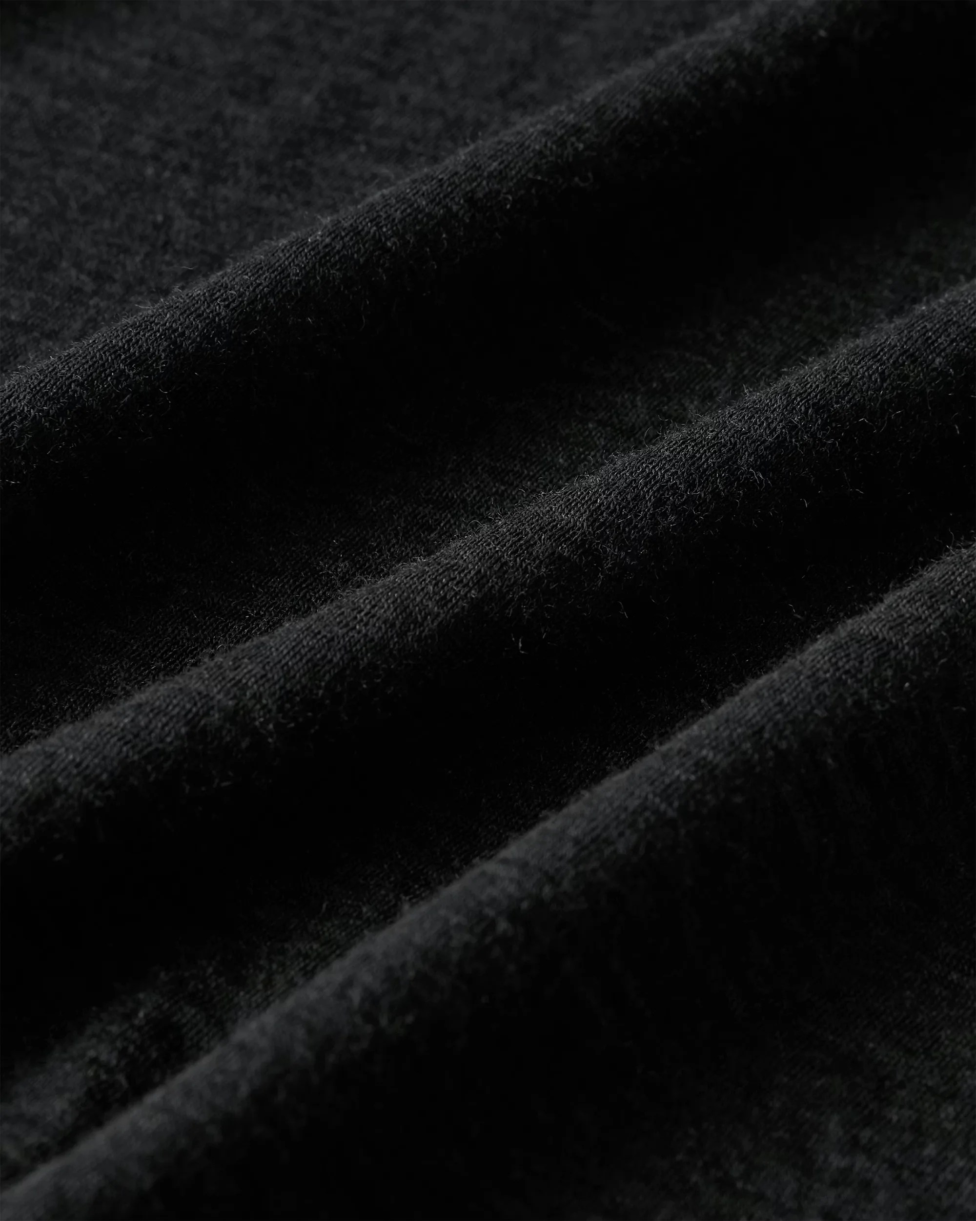 Close-up of soft black fabric with visible texture and folds.