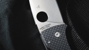 Close-up of a folding knife blade with a circular hole and textured handle, engraved with "Golden, Colorado U.S.A. Earth.