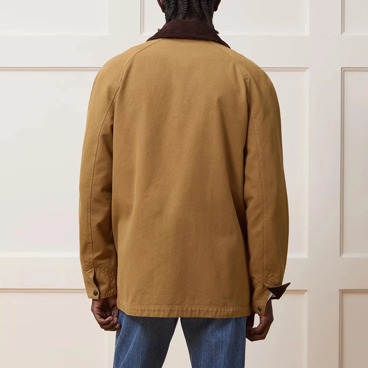 Brown canvas jacket with dark brown collar worn by a person facing away.