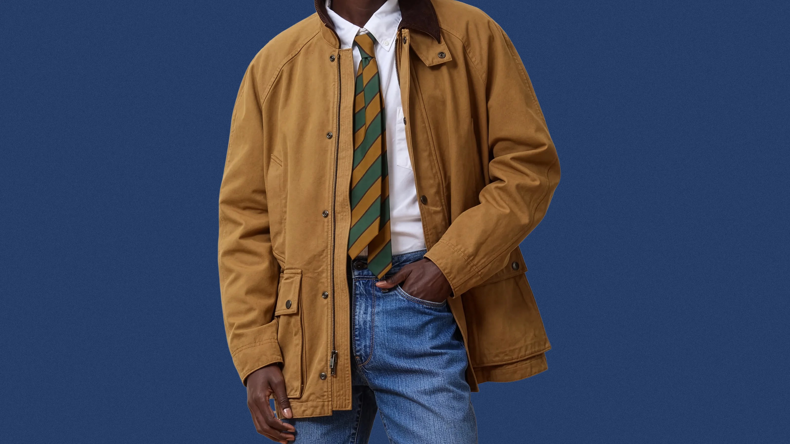 Brown cotton jacket with snap pockets worn over a white shirt and striped green and brown tie.