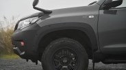 Close-up of a black off-road vehicle's front left wheel with rugged tire and "Cargo by The North Face" badge on the fender.