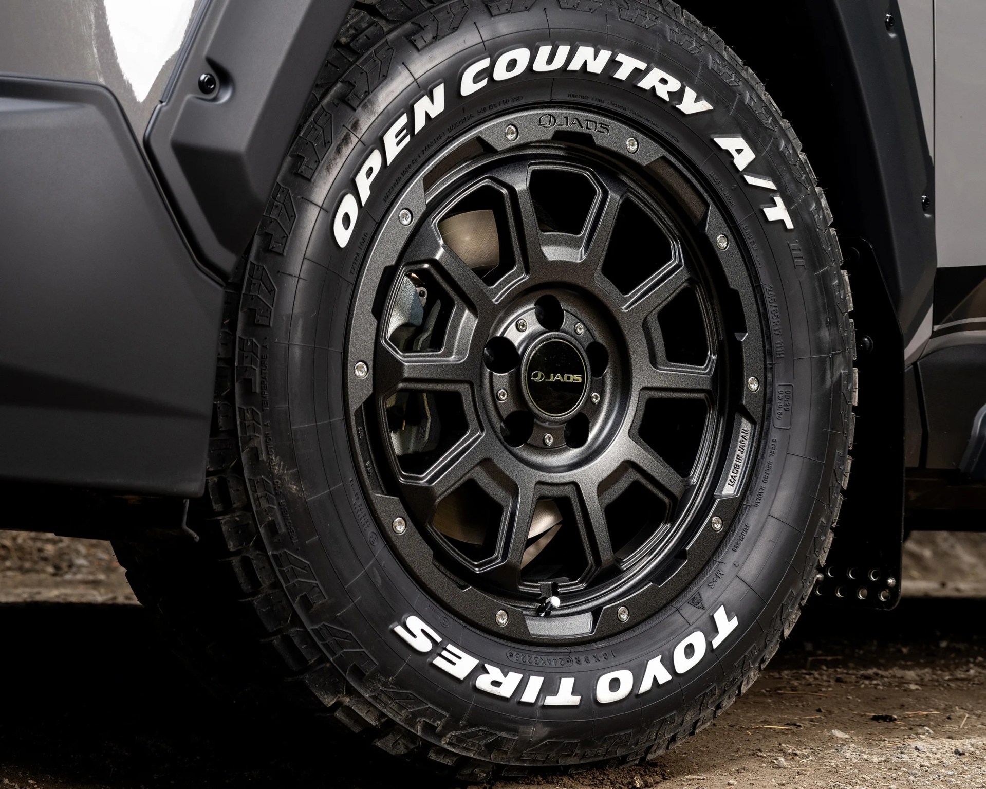 Black JAOS alloy wheel with Toyo Open Country A/T tire featuring white lettering on a vehicle.