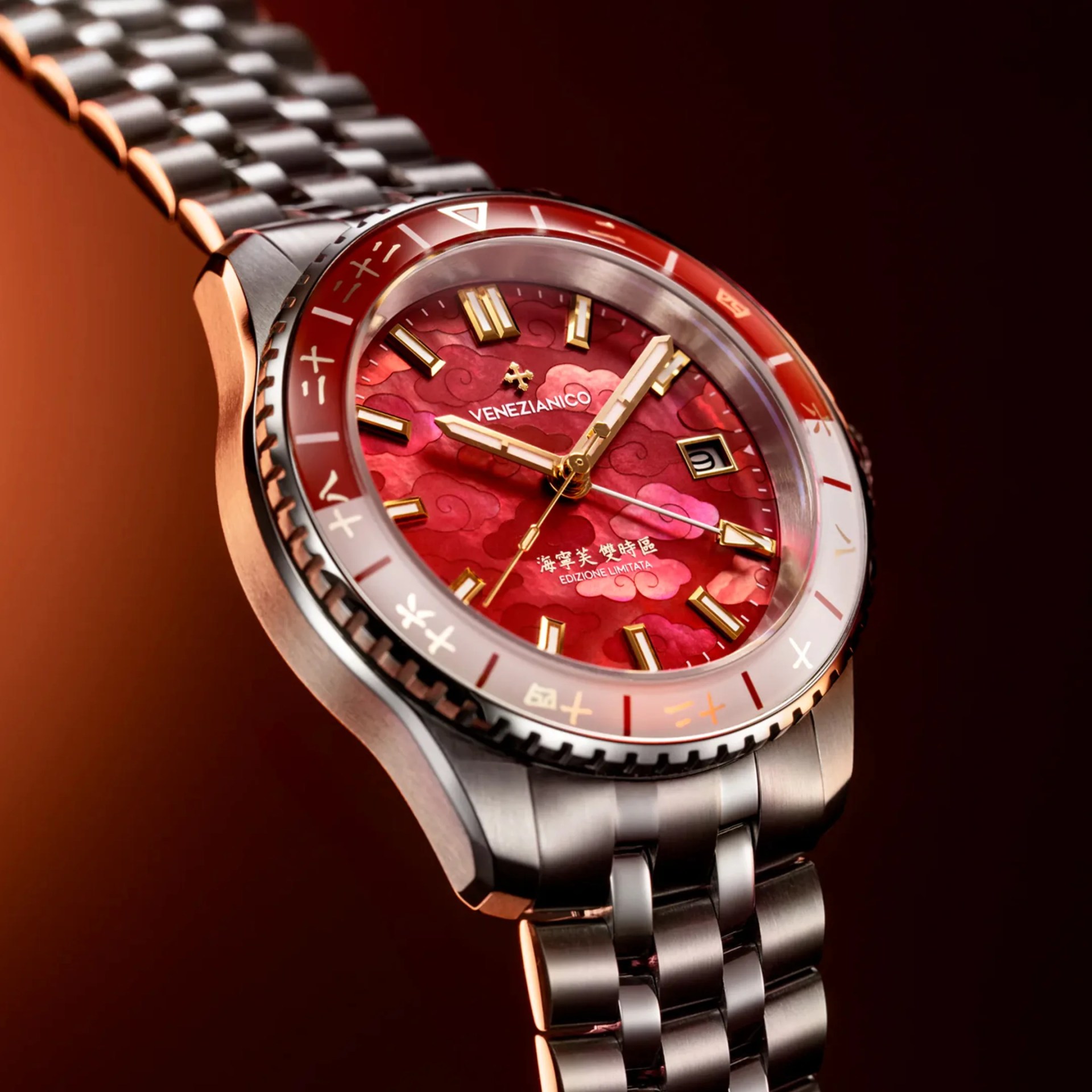 Stainless steel wristwatch with red patterned dial, gold hour markers, and red and white bezel.