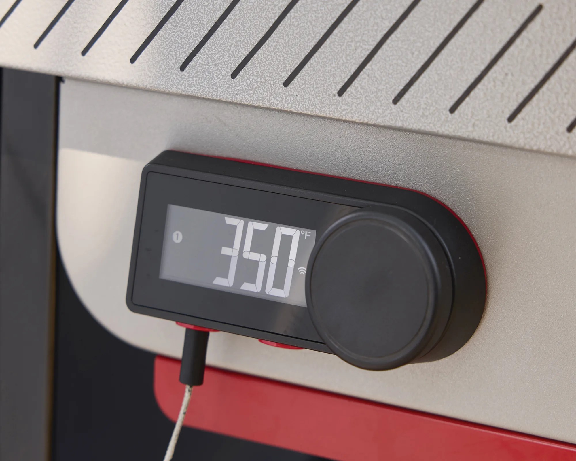 Digital temperature control panel showing 350&deg;F with a black dial and probe attached to a metallic surface.