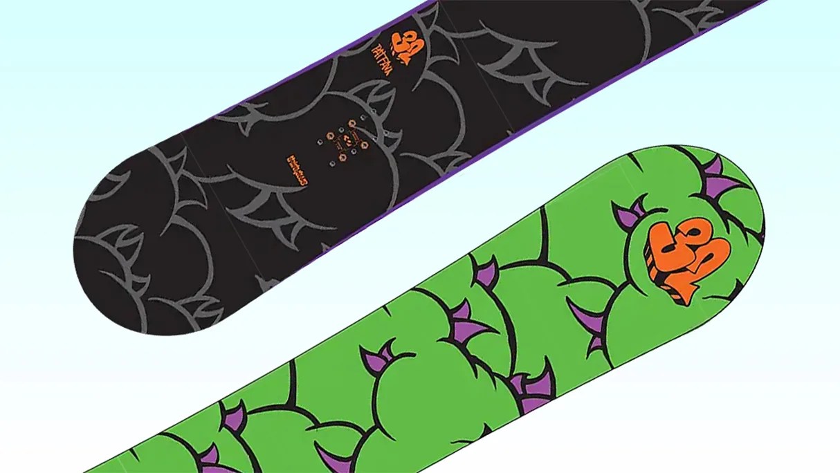 Two snowboards with cartoonish green and black designs featuring purple spikes and orange "39" logos on a light blue background.