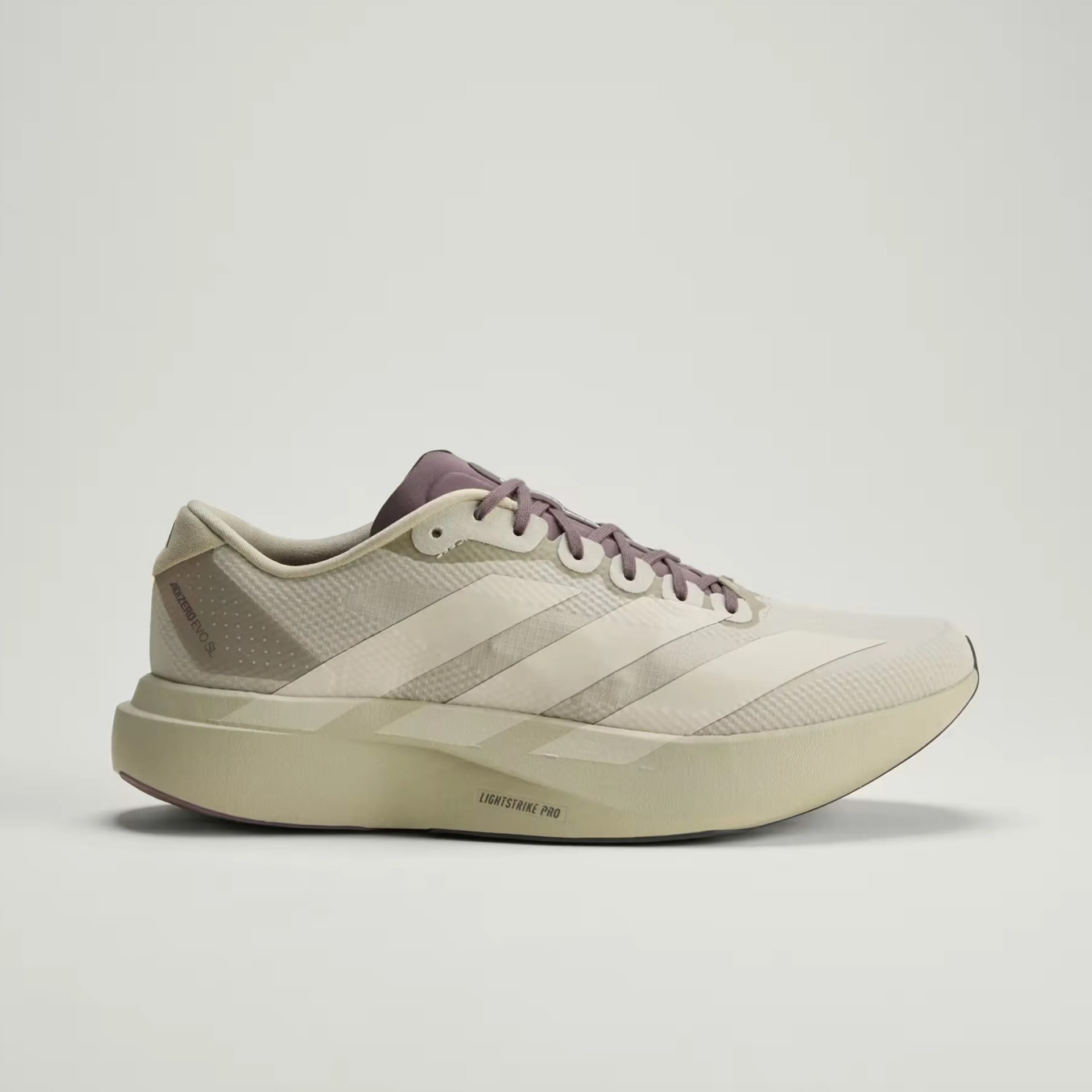 Beige Adidas Adizero running shoe with light purple laces and Lightstrike Pro sole.