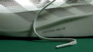 Close-up of a white sneaker with perforated triangular patterns and "LIGHTSTRIKE PRO EVO" text, with a white shoelace on a green surface.