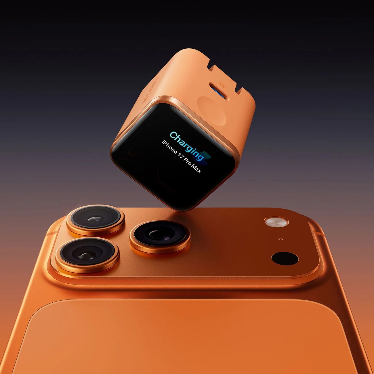 Orange iPhone 17 Pro Max with three rear cameras and a matching orange charging cube displaying 