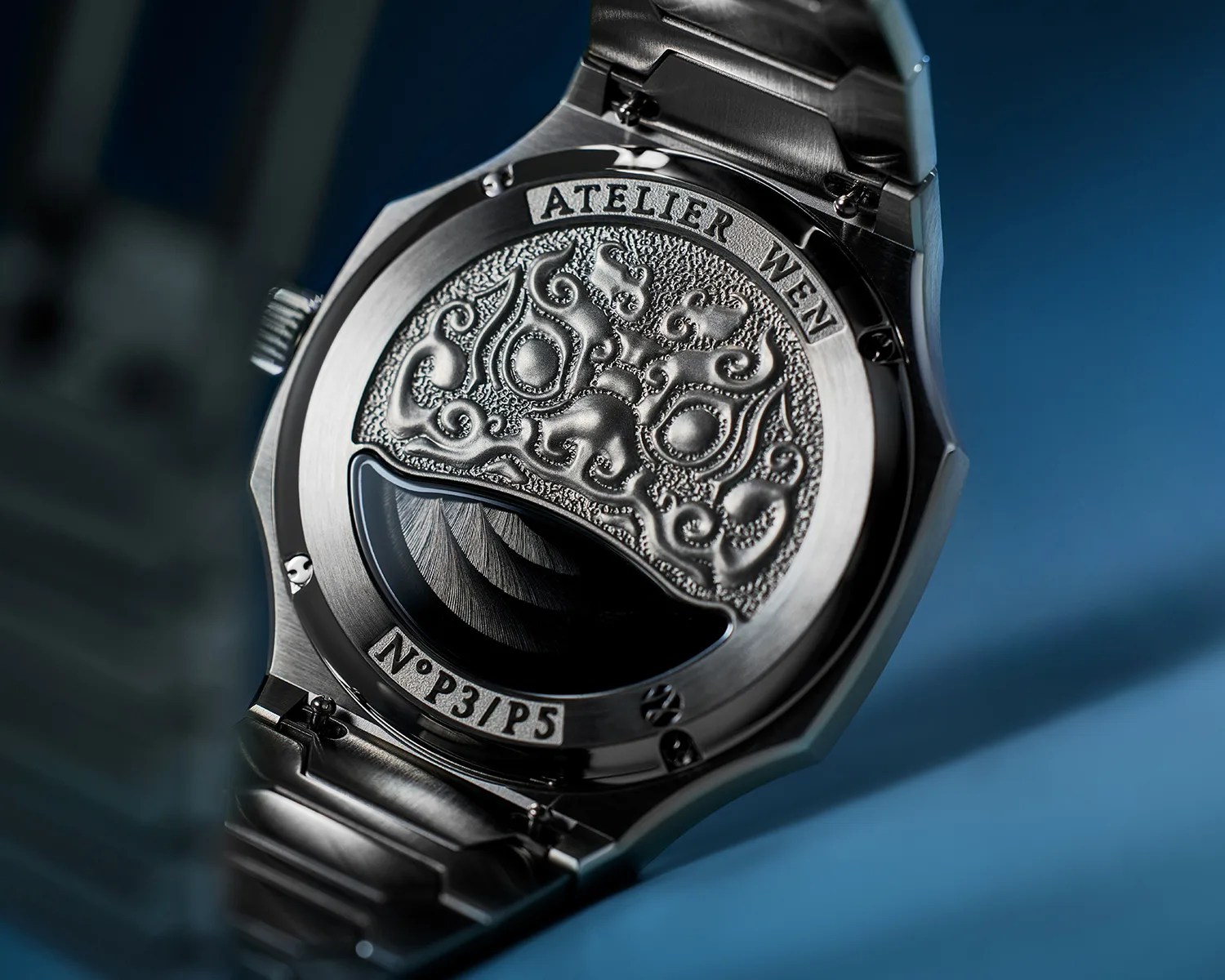 Close-up of a stainless steel Atelier Wen watch back with intricate embossed design and serial number N°P3/P5.