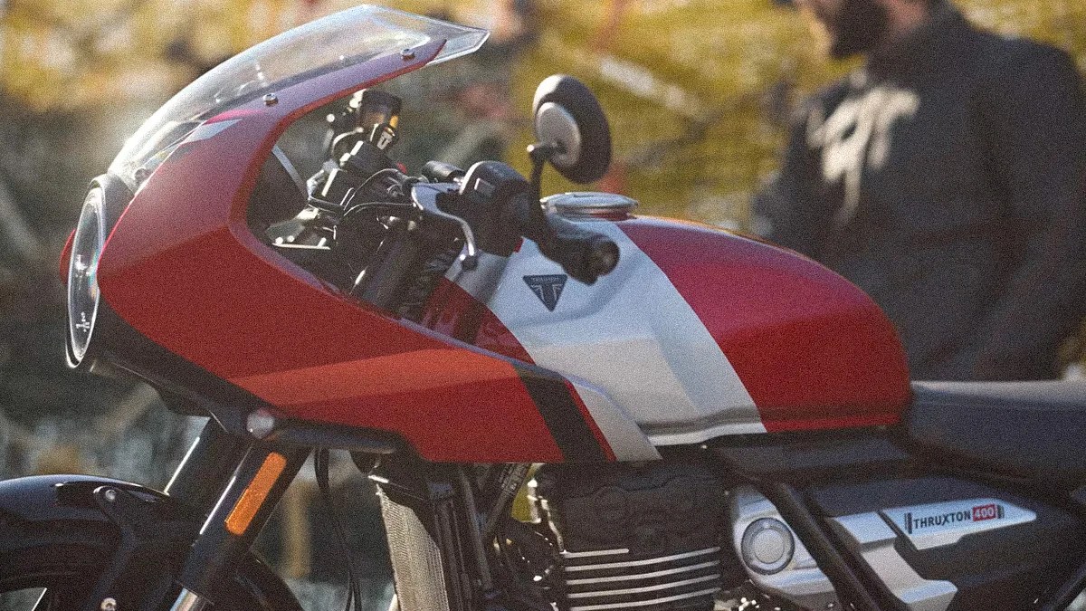 Red and white Triumph Thruxton 1200 motorcycle with a clear windshield and round headlight.