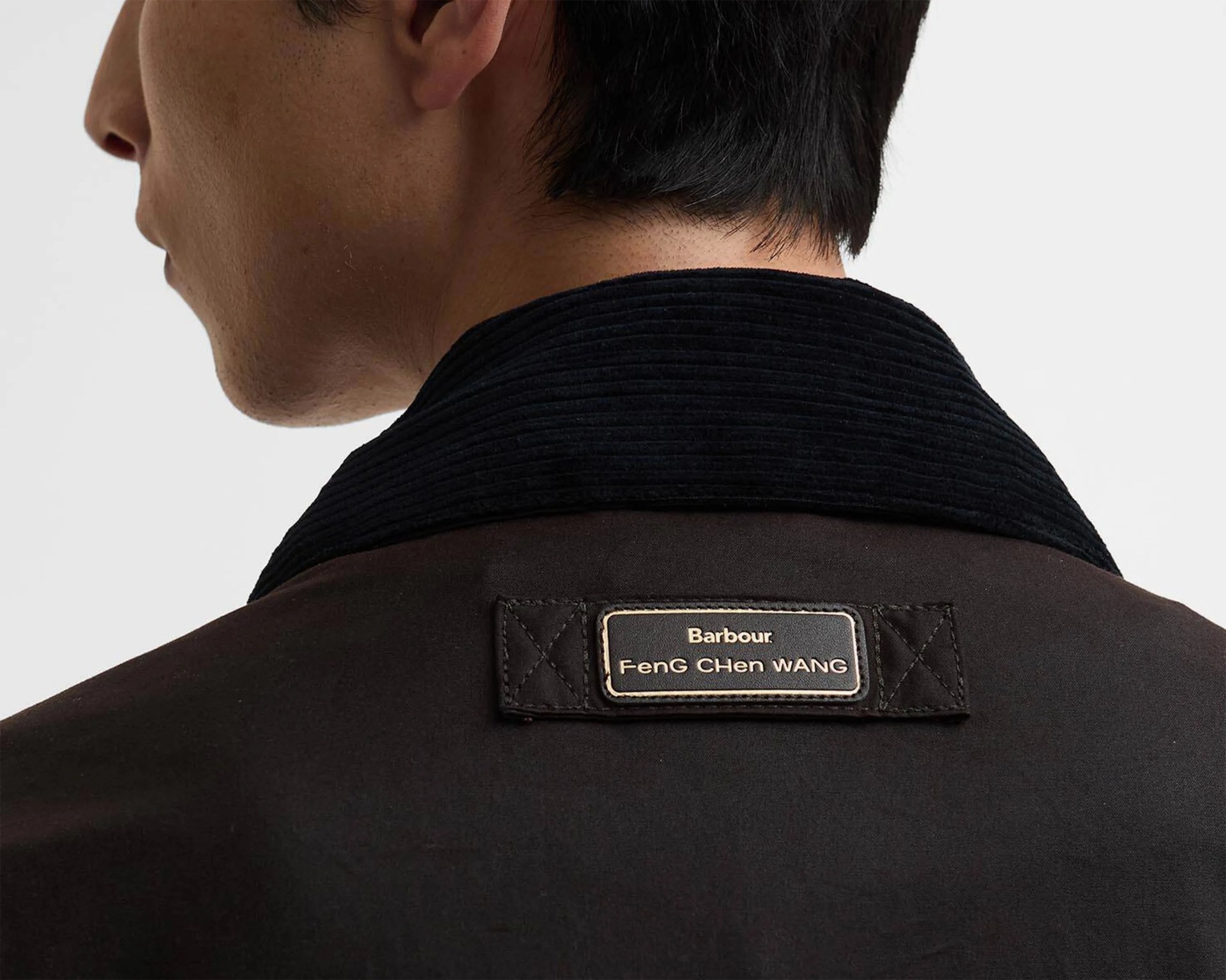 Close-up of a black jacket collar with a Barbour Feng Chen Wang label on the back.