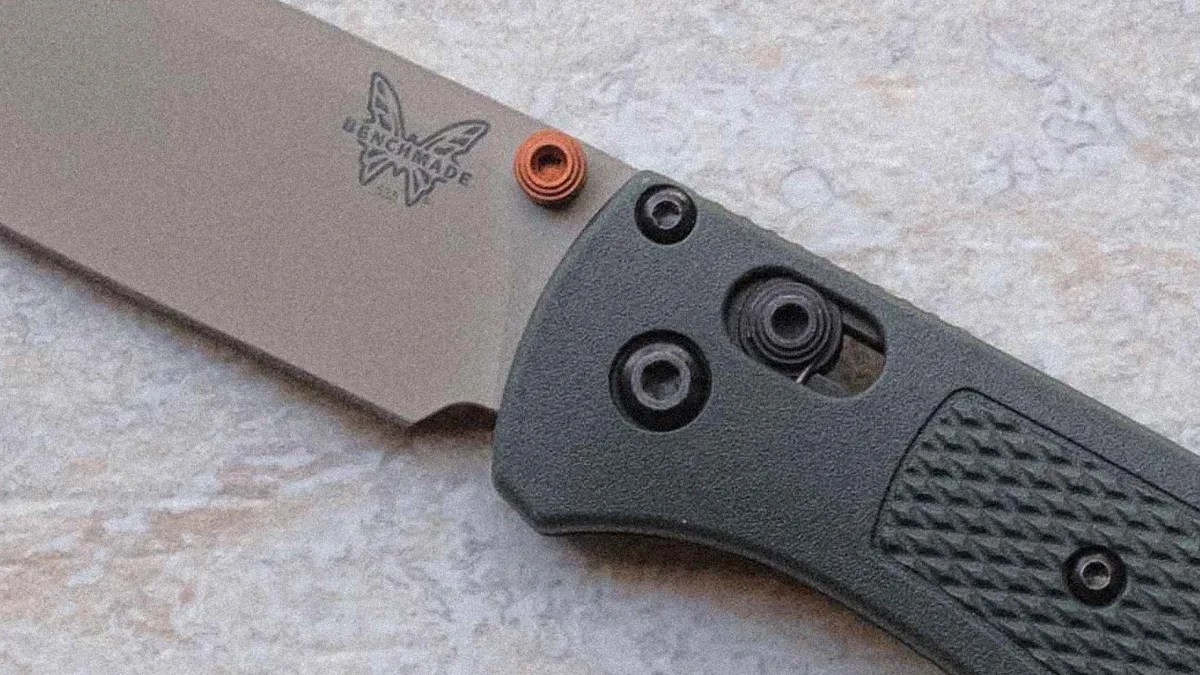 Close-up of a Benchmade folding knife with a gray blade and textured black handle.