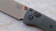 Close-up of a Benchmade folding knife with a gray blade and textured black handle.