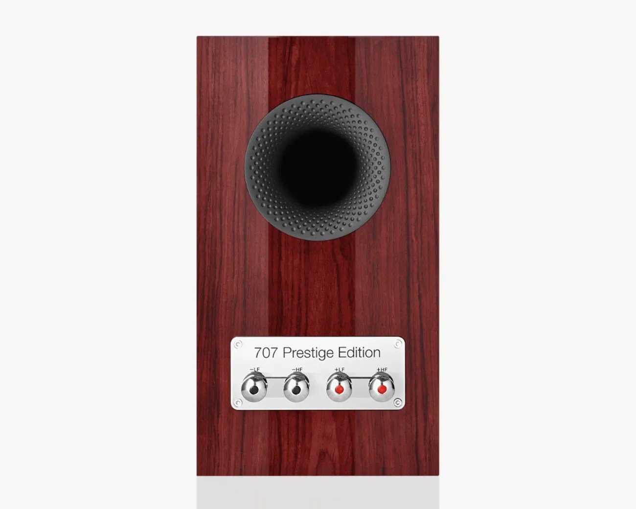 Wood-finished speaker with a black circular port and a metal plate labeled "707 Prestige Edition" with four adjustment knobs.