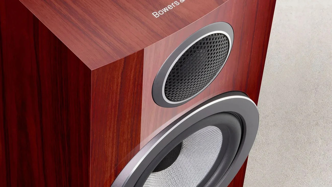 Glossy wooden speaker cabinet with black and silver speaker drivers and partial "Bowers & Wilkins" logo.