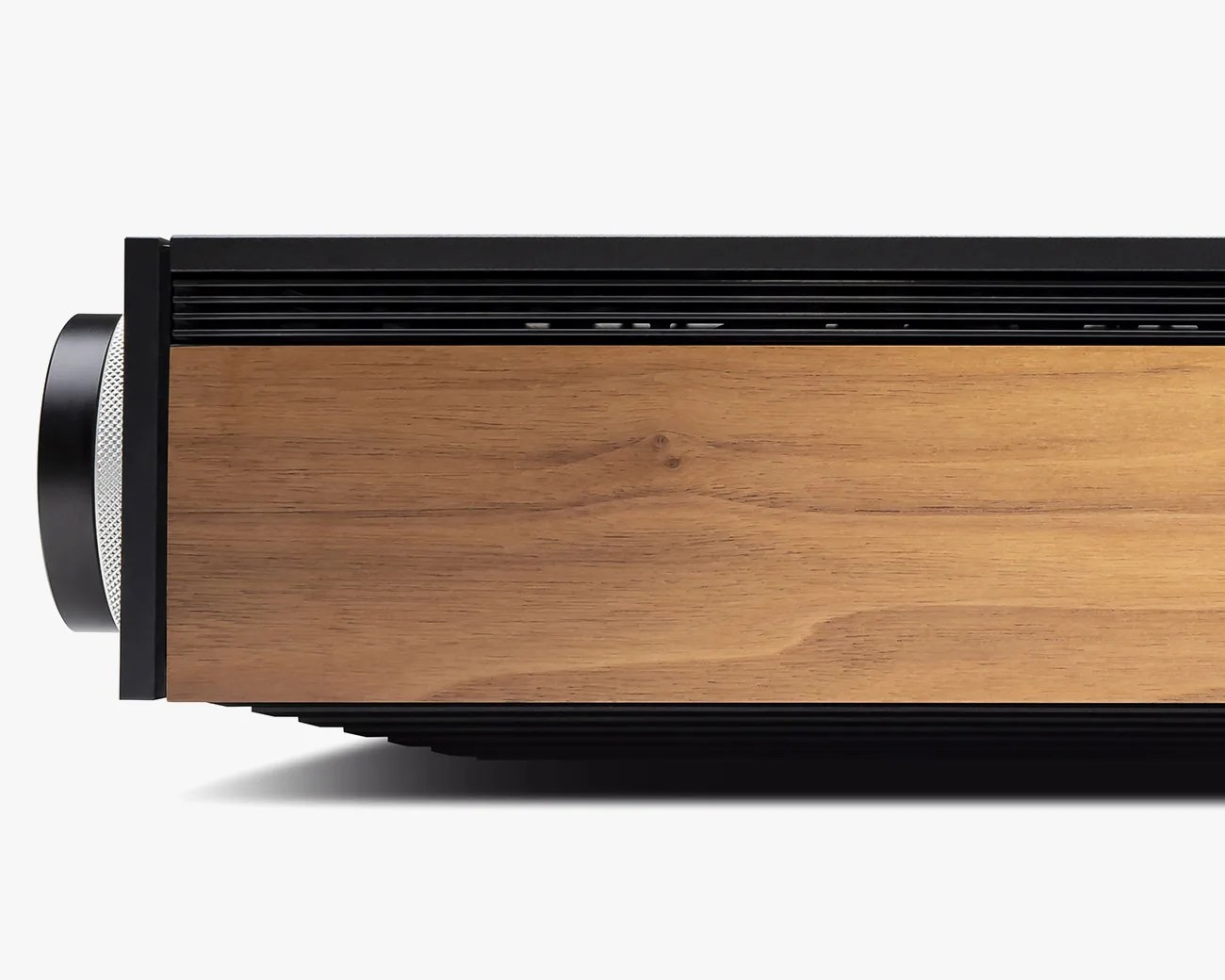 Side view of a black and wood-finished electronic device with a silver textured knob on the left.