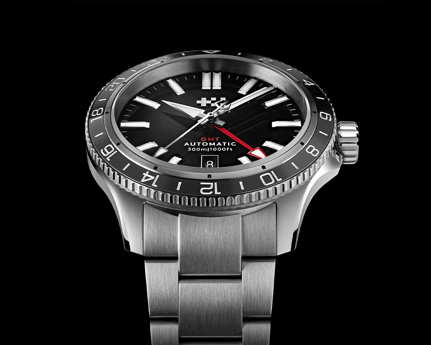 Stainless steel GMT automatic wristwatch with black dial, red GMT hand, and 24-hour bezel on a metal bracelet.