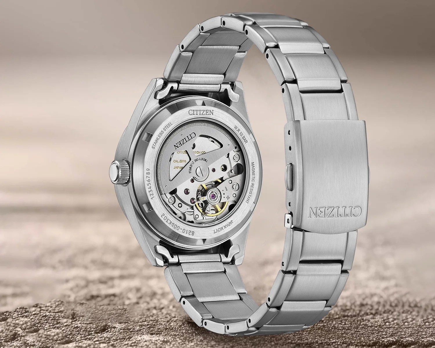 Stainless steel Citizen wristwatch with visible automatic movement and metal bracelet clasp.