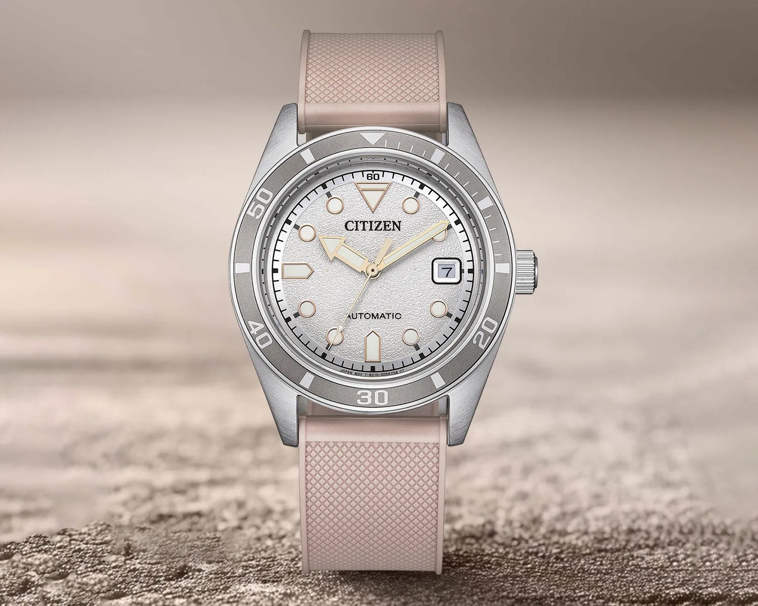 Silver Citizen automatic wristwatch with textured white dial, beige hands, date window, and beige textured rubber strap.
