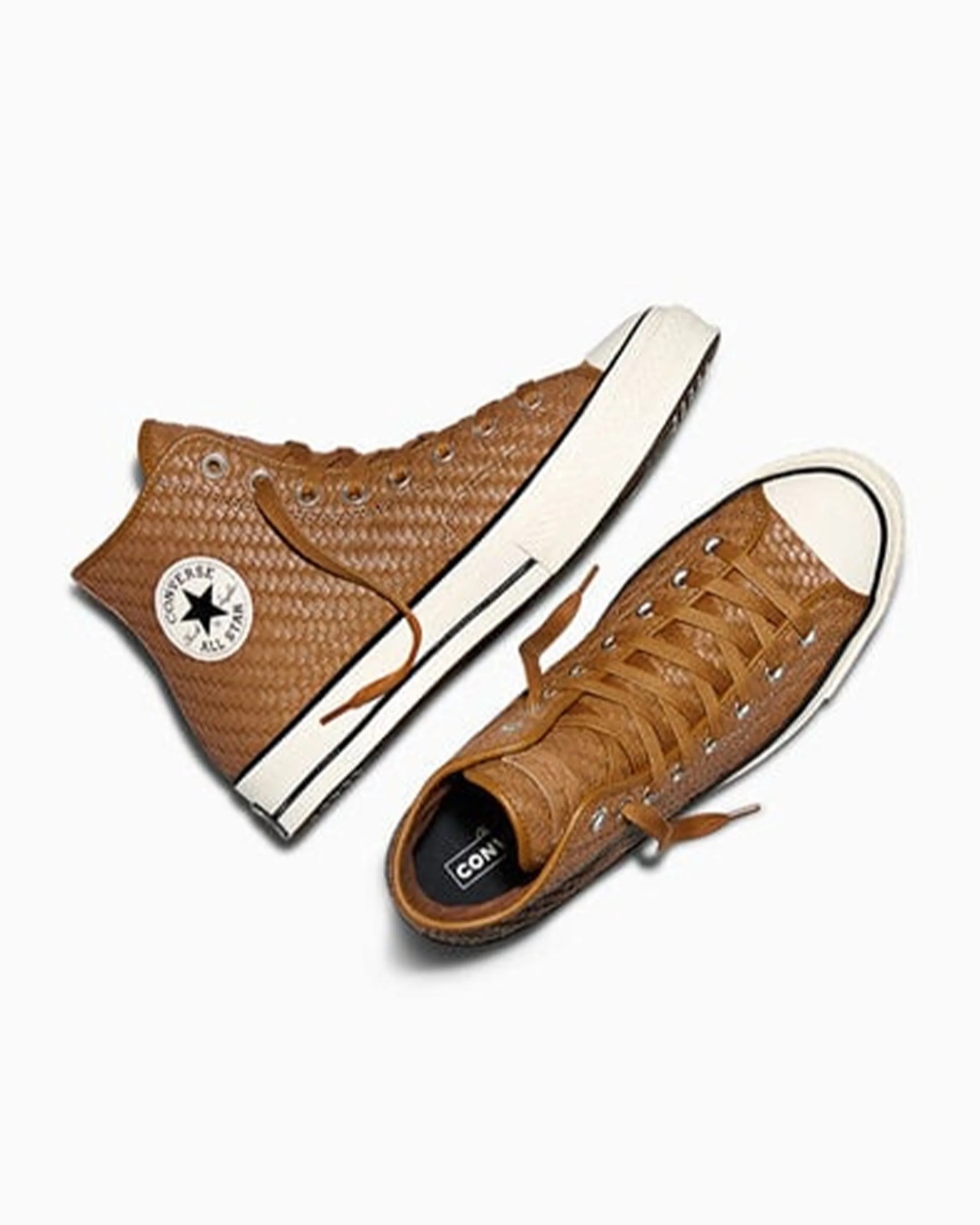 Pair of brown high-top Converse All Star sneakers with textured leather and white rubber soles.