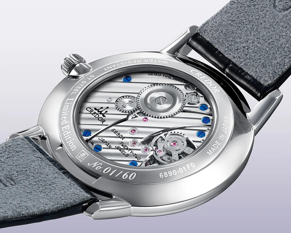 Close-up of the back of a Credor limited edition stainless steel watch with visible mechanical movement and grey leather strap.