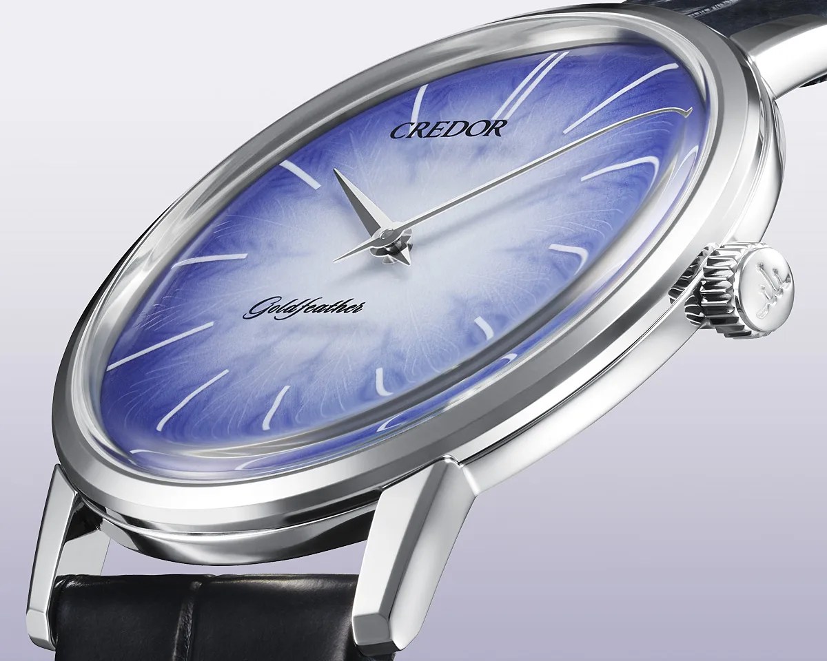 Silver wristwatch with a blue gradient dial featuring delicate feather-like patterns and black leather strap.