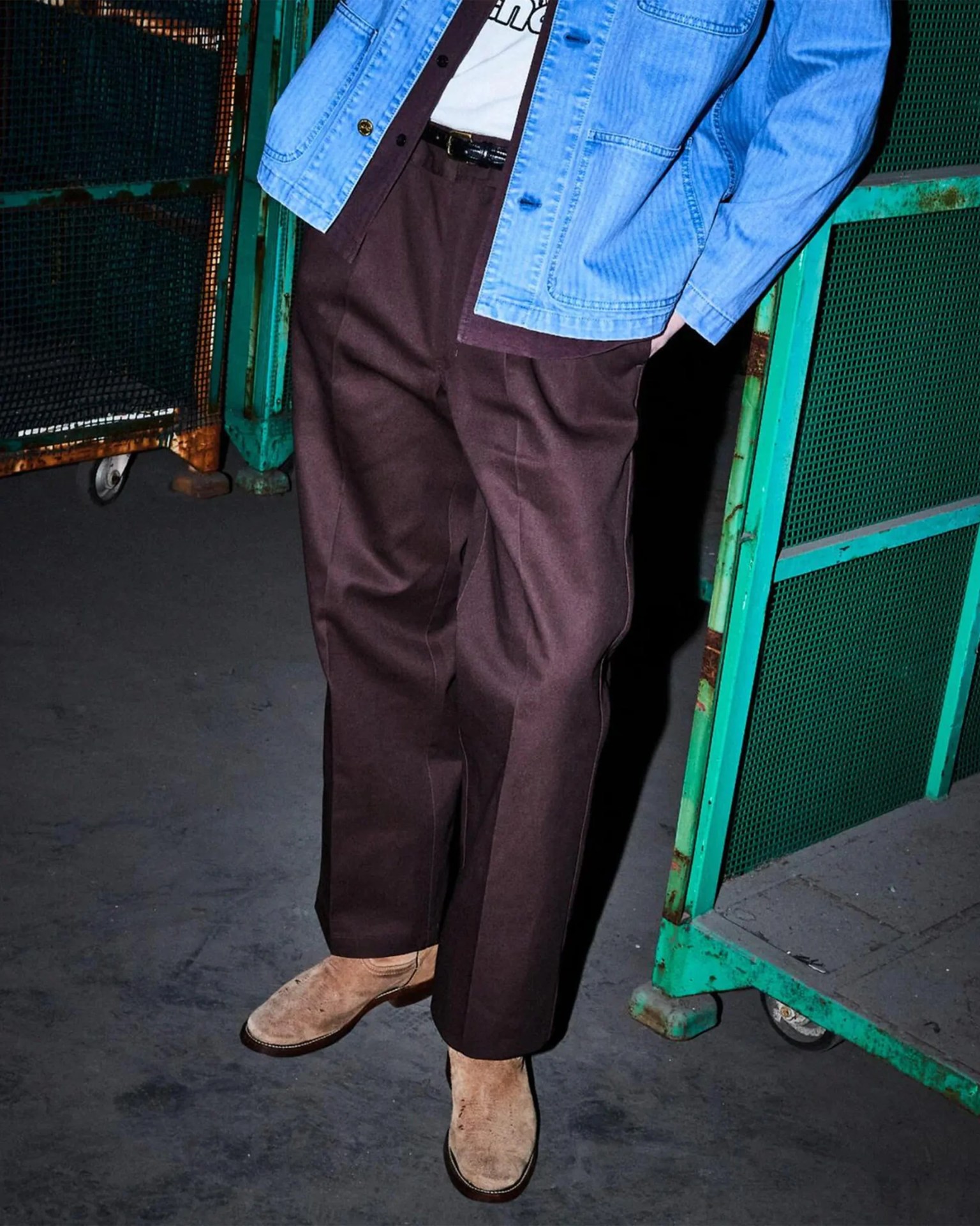 Brown wide-leg trousers paired with beige suede boots and a light blue denim jacket.