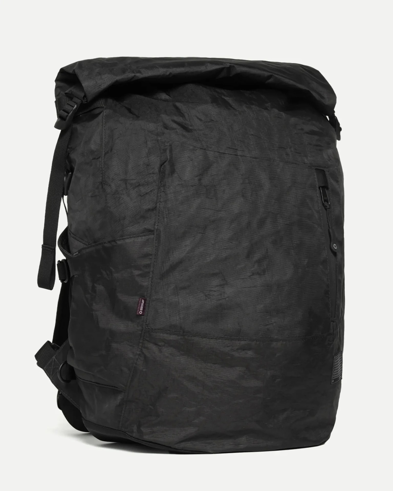 Black roll-top backpack with a front zippered pocket and adjustable side straps.