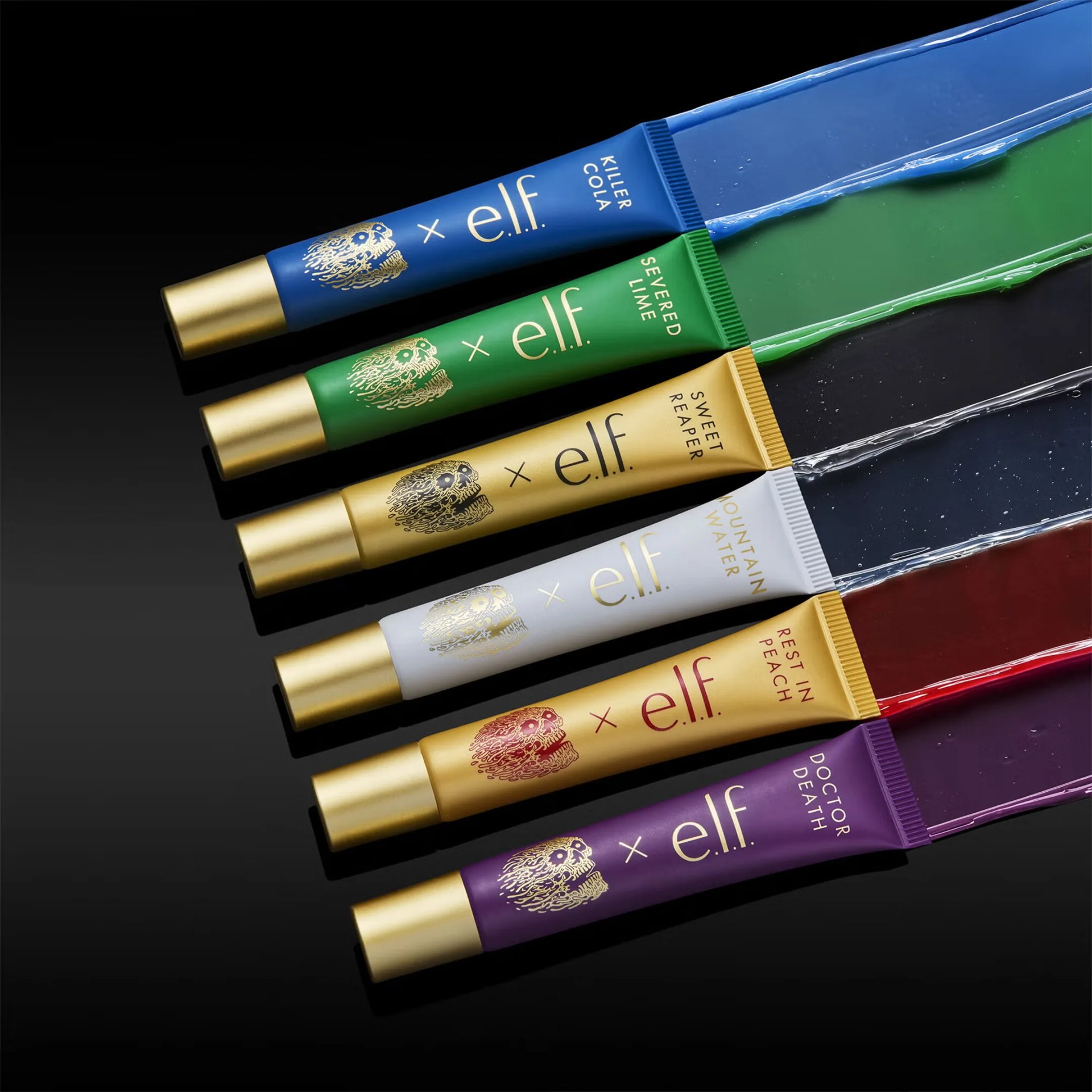 Six tubes of e.l.f. lip gloss in blue, green, gold, white, gold, and purple with matching gloss swatches on a black surface.