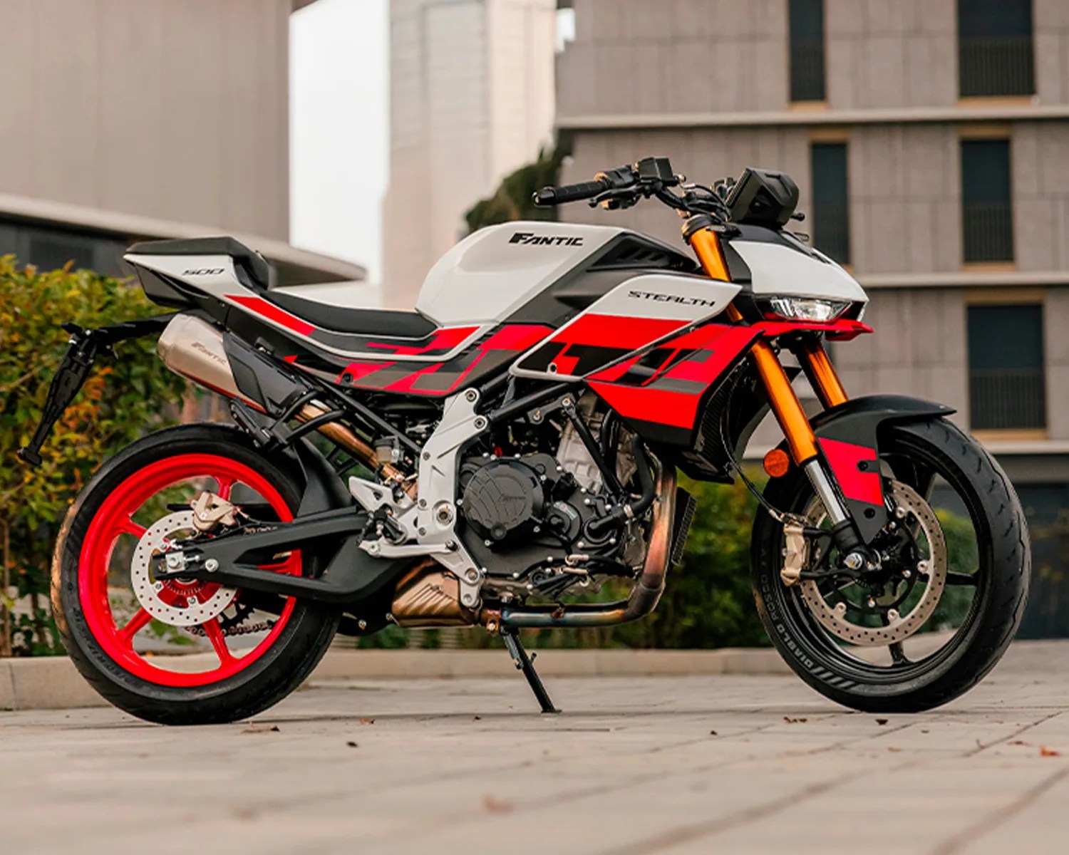 White and red Fantic Stealth 500 motorcycle with orange front forks parked on a paved surface.