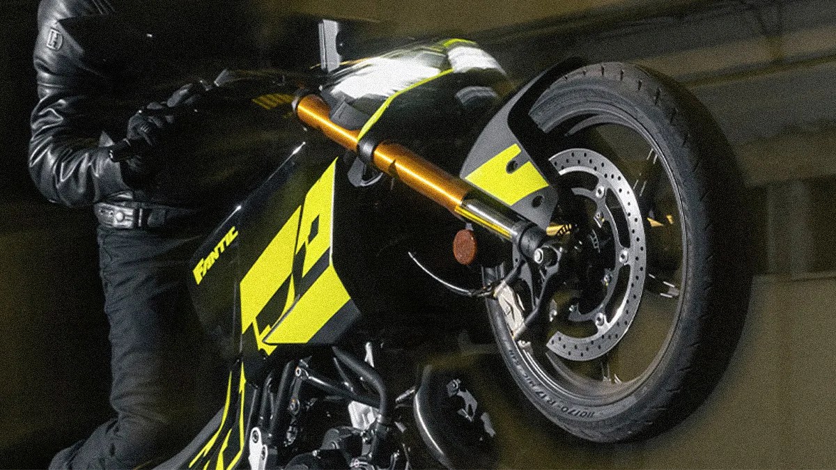 Black and yellow Fantic motorcycle with front wheel lifted, ridden by a person in black leather gear.