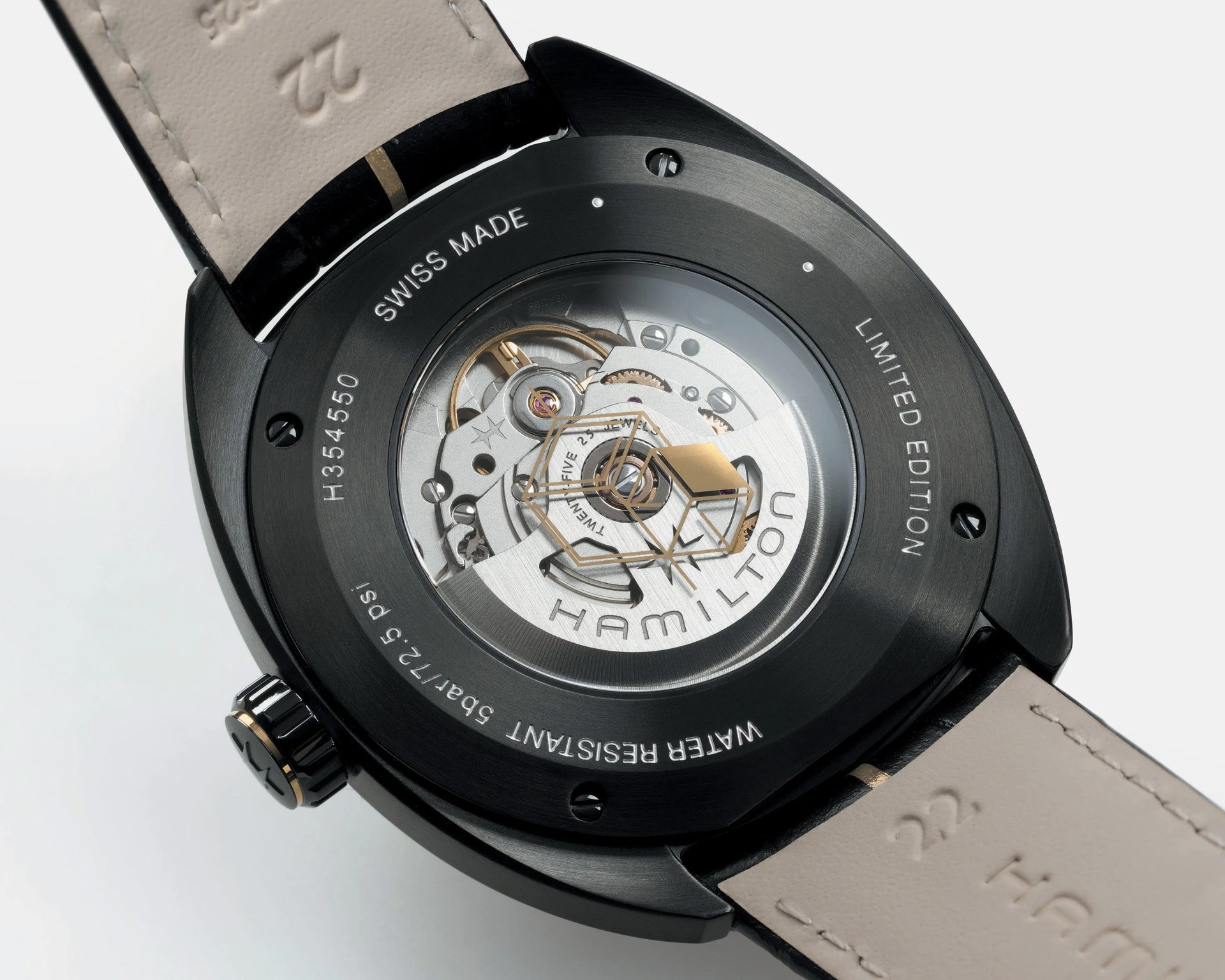 Back of a black Hamilton watch with visible automatic movement and beige leather strap.