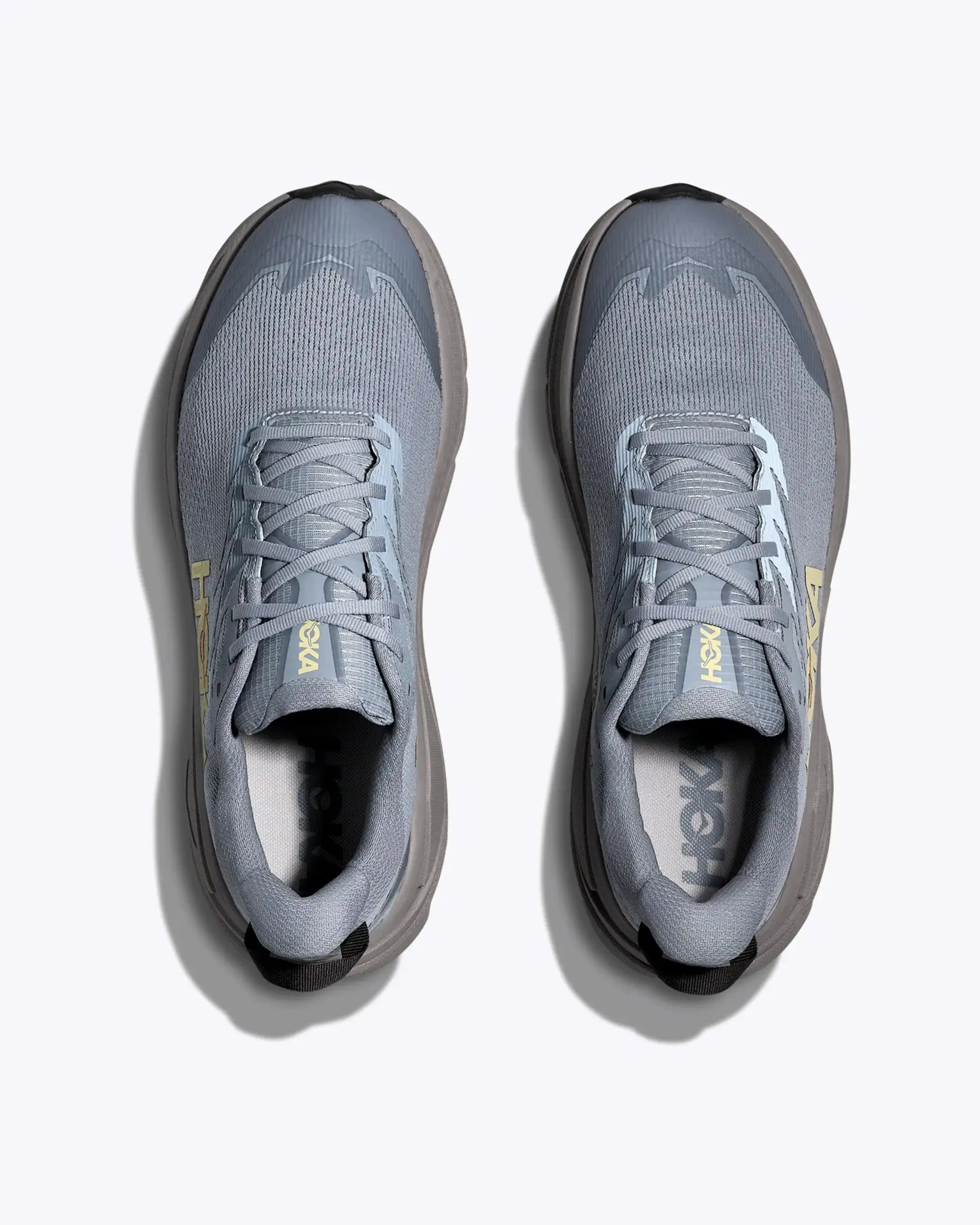 Pair of gray Hoka running shoes with light blue accents and yellow logo viewed from above.