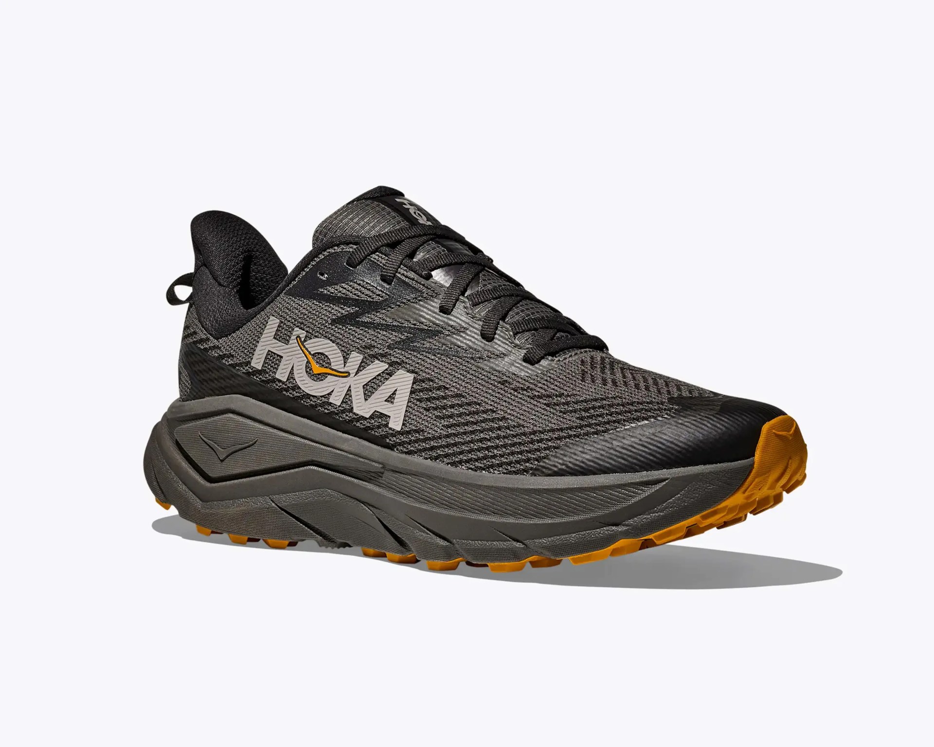Gray and black Hoka running shoe with orange sole and large logo on the side.