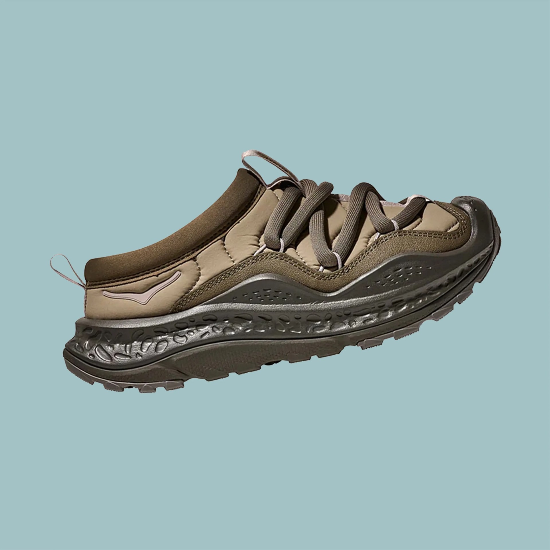 Brown and olive green sneaker with thick textured sole and loop pull tabs on a blue background.
