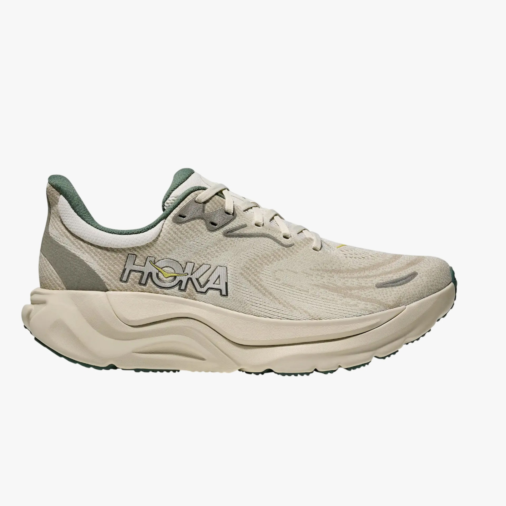 Beige and green Hoka running shoe with thick cushioned sole and mesh upper.