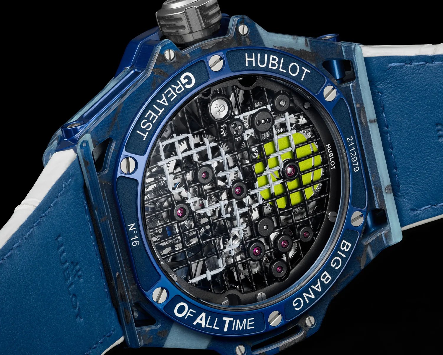 Back of a blue Hublot Big Bang wristwatch with visible intricate gears and a tennis ball design under a grid pattern.