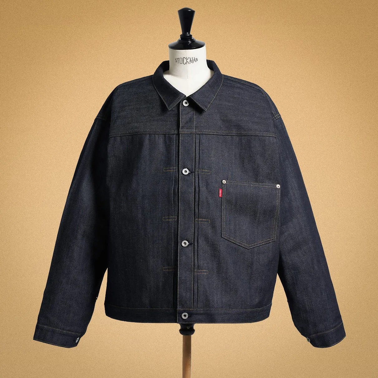Dark indigo denim jacket with button front and single chest pocket on a mannequin.