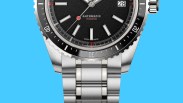 Close-up of a stainless steel automatic wristwatch with a black textured dial, date window, and rotating bezel.