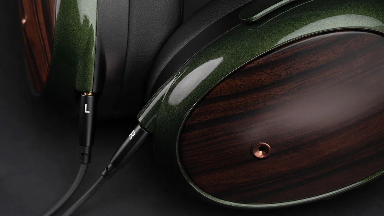 Over-ear headphones with dark green metallic frame and wooden ear cups connected by black cables marked L and R.