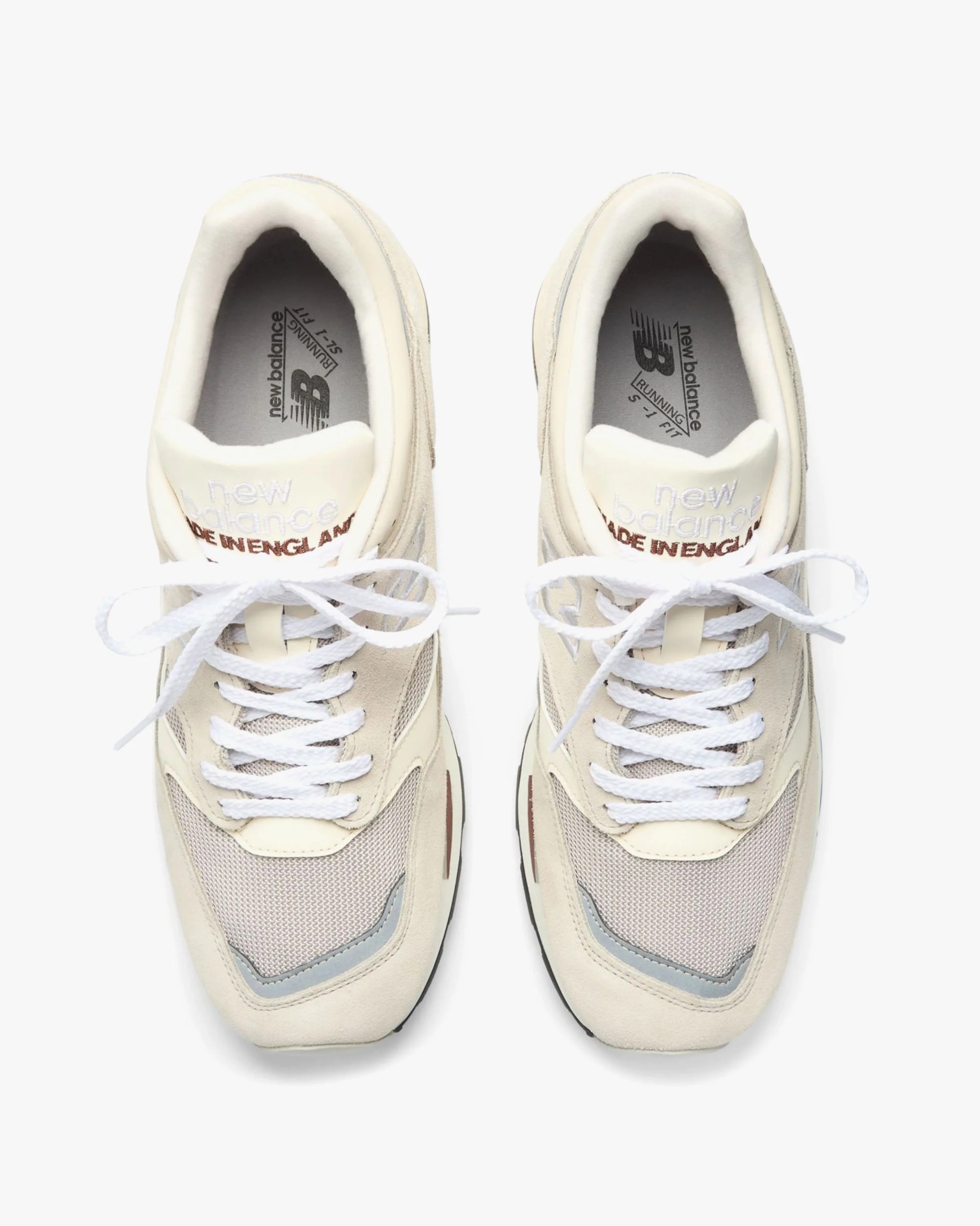Pair of beige New Balance sneakers with white laces and "Made in England" text on the tongue.